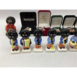Eight ceramic Golly Band figurines marked Carlton Ware, together with four other Golly figures and five boxed badges