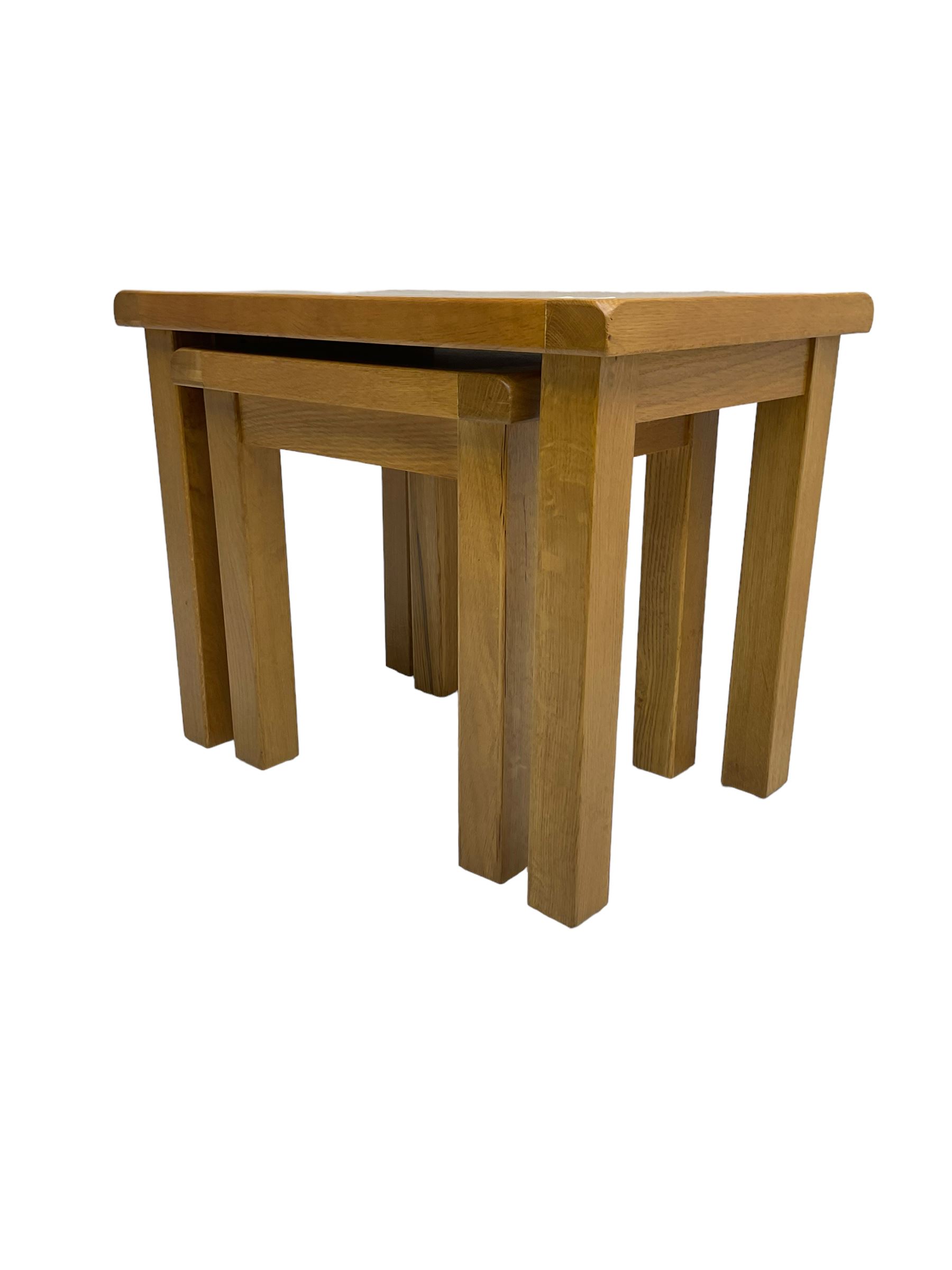 Light oak nest of two tables, rectangular top raised on square supports