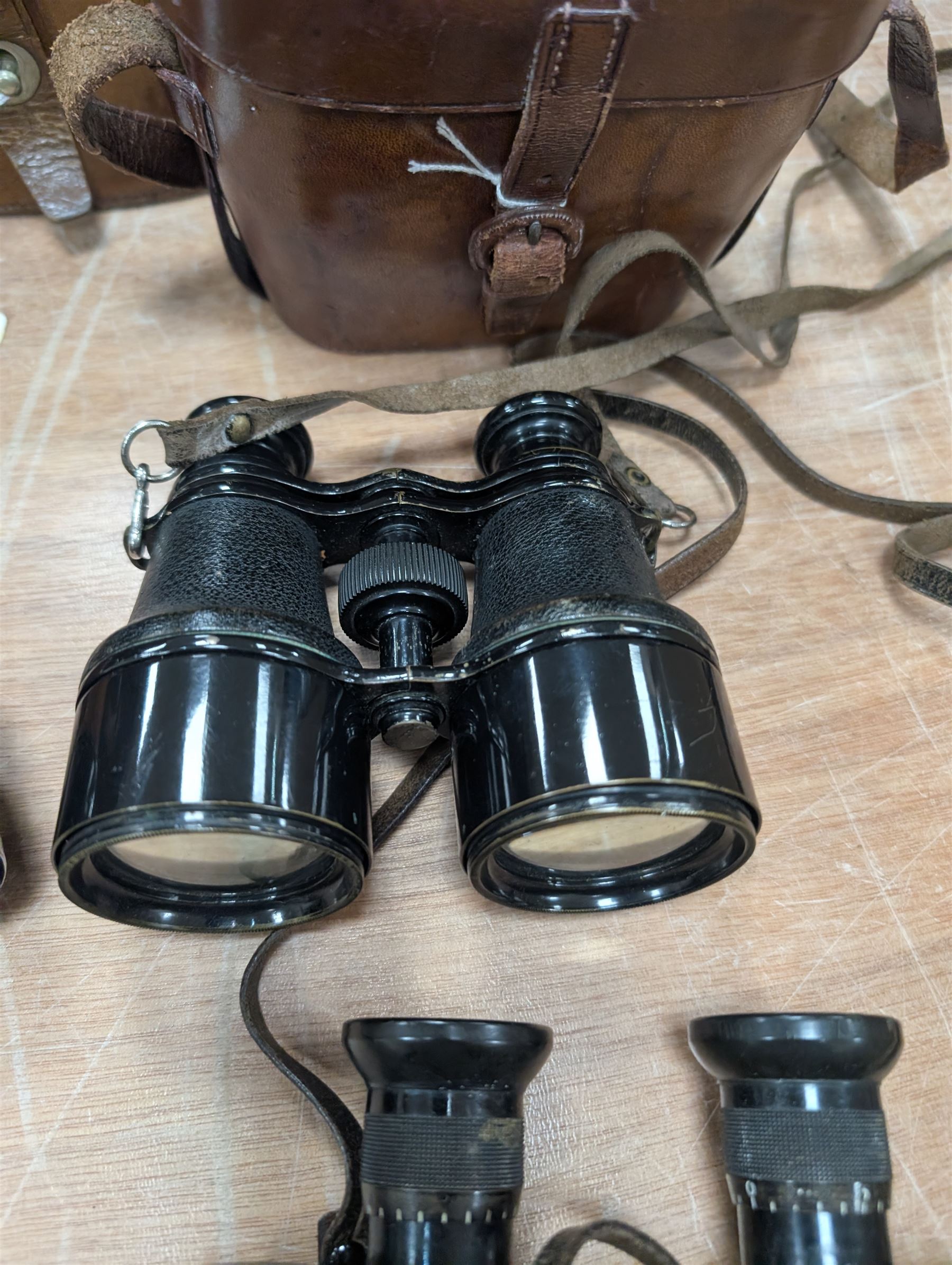 Four pairs of early 20th century binoculars, including Carl Zeiss Jena Feldstecher binoculars, Carl Zeiss Telact 8x binoculars, Dollond x5 field binolculars and one other pair, all in leather cases, one case marked with broad arrow, some with officers name etched