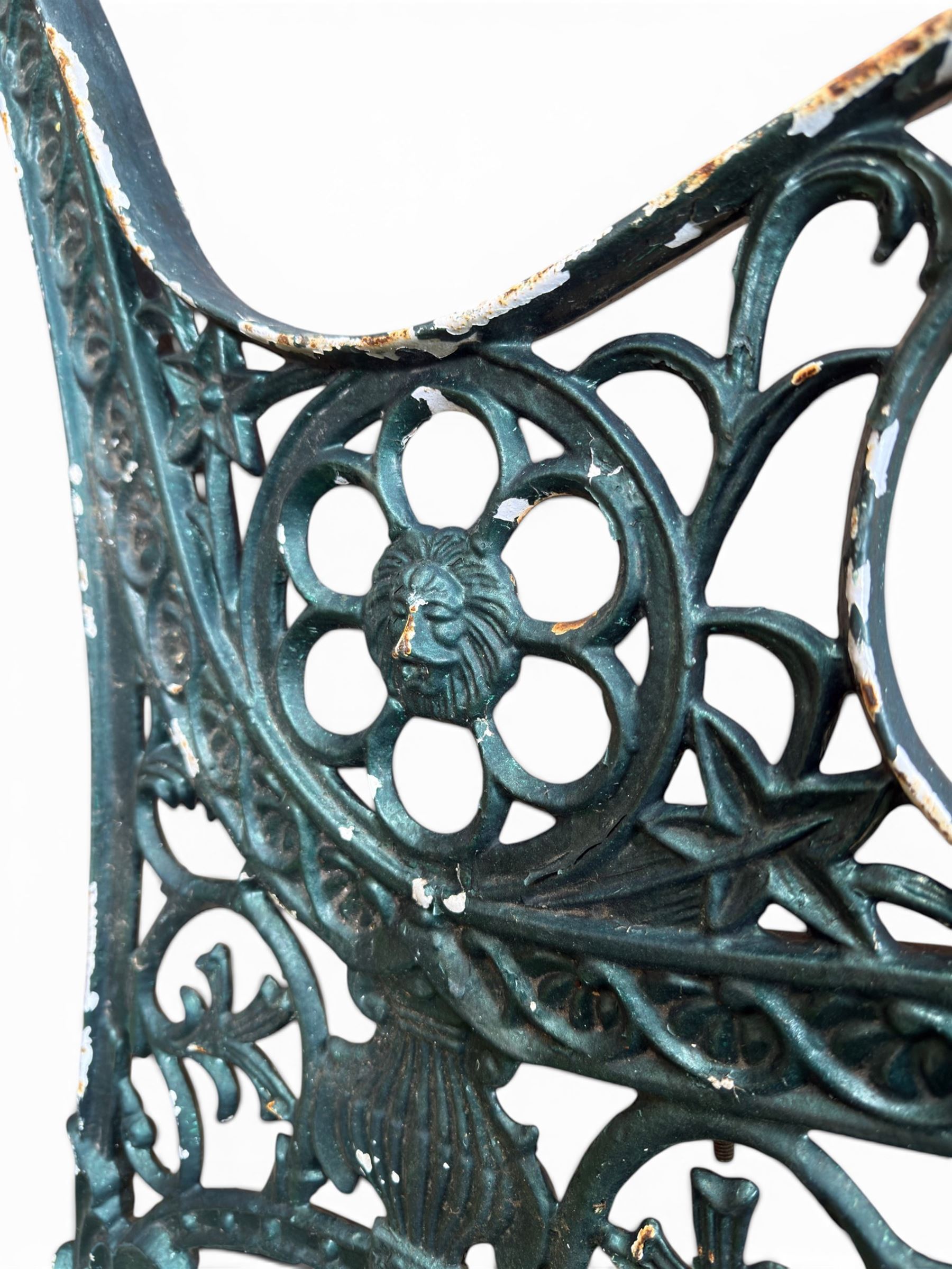 Pair of ornate painted cast iron bench ends, painted in green