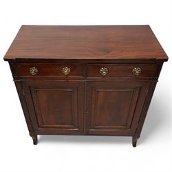 Regency mahogany cupboard, rectangular shaped top over two cock-beaded frieze drawers, fitted with brass Yorkshire rose pull handles, over two panelled and cross-banded cupboards, flanked by reeded uprights, raised on curved feet