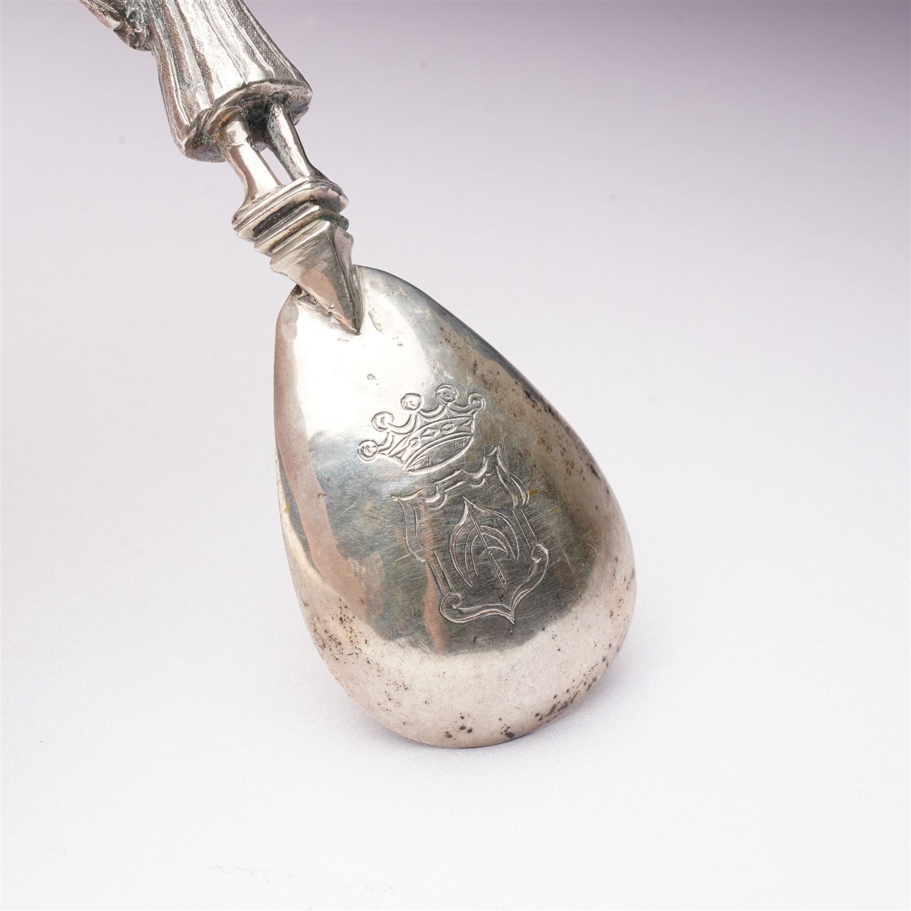 19th century Dutch silver spoon with hammered ovoid bowl, the reverse with a coat of arms, the stem formed as a standing figure after a 17th century design L13cm