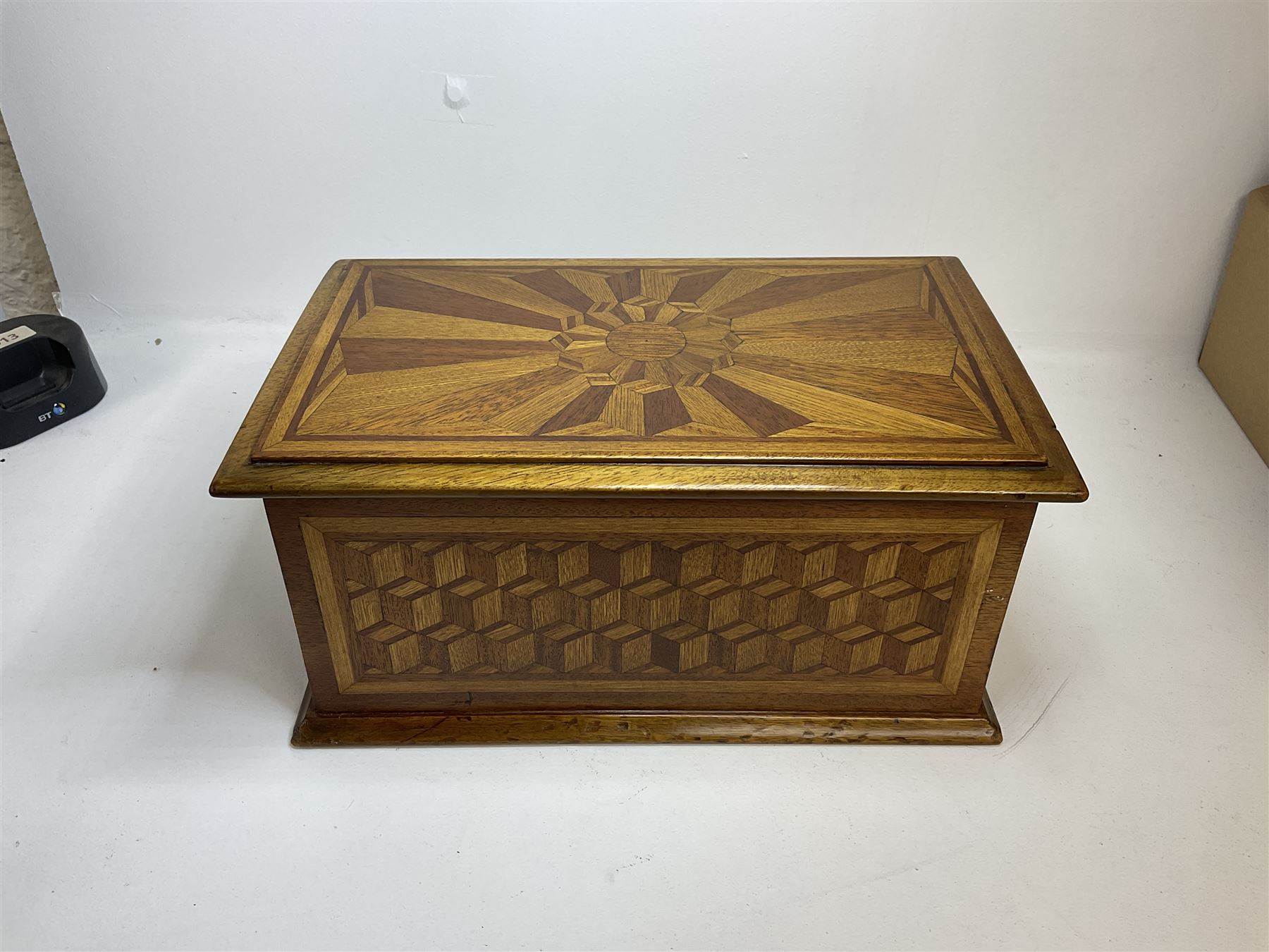 19th Century mahogany and parquetry box of rectangular form, geometric cube design, with a stylised sun detail to the hinged cover, opening to reveal three compartments, L33cm D21cm H16cm
