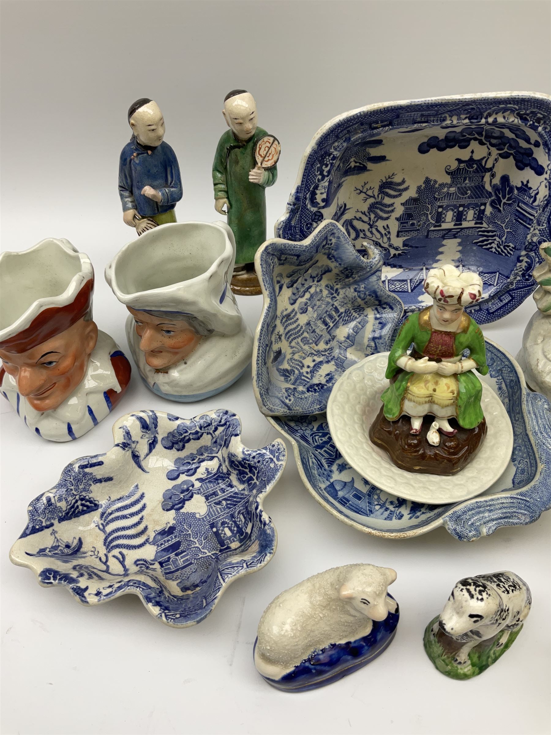 Two 19th century blue and white pickle dishes, each decorated in a variant of the Willow pattern, 19th century blue and white Willow pattern dessert dish, further Willow pattern dish, two black basalt jugs, small Victorian cockle dish, plus a group of Victorian and later figures, to include two Staffordshire arbour groups, one with beehive, Staffordshire style model of a sheep, two Sitzendorf monkey band figures, a Continental figure group modelled as a dancing couple, Atlas China figure of a Satyr, two jugs modelled as Punch and Judy, Rd no 139844, etc. 