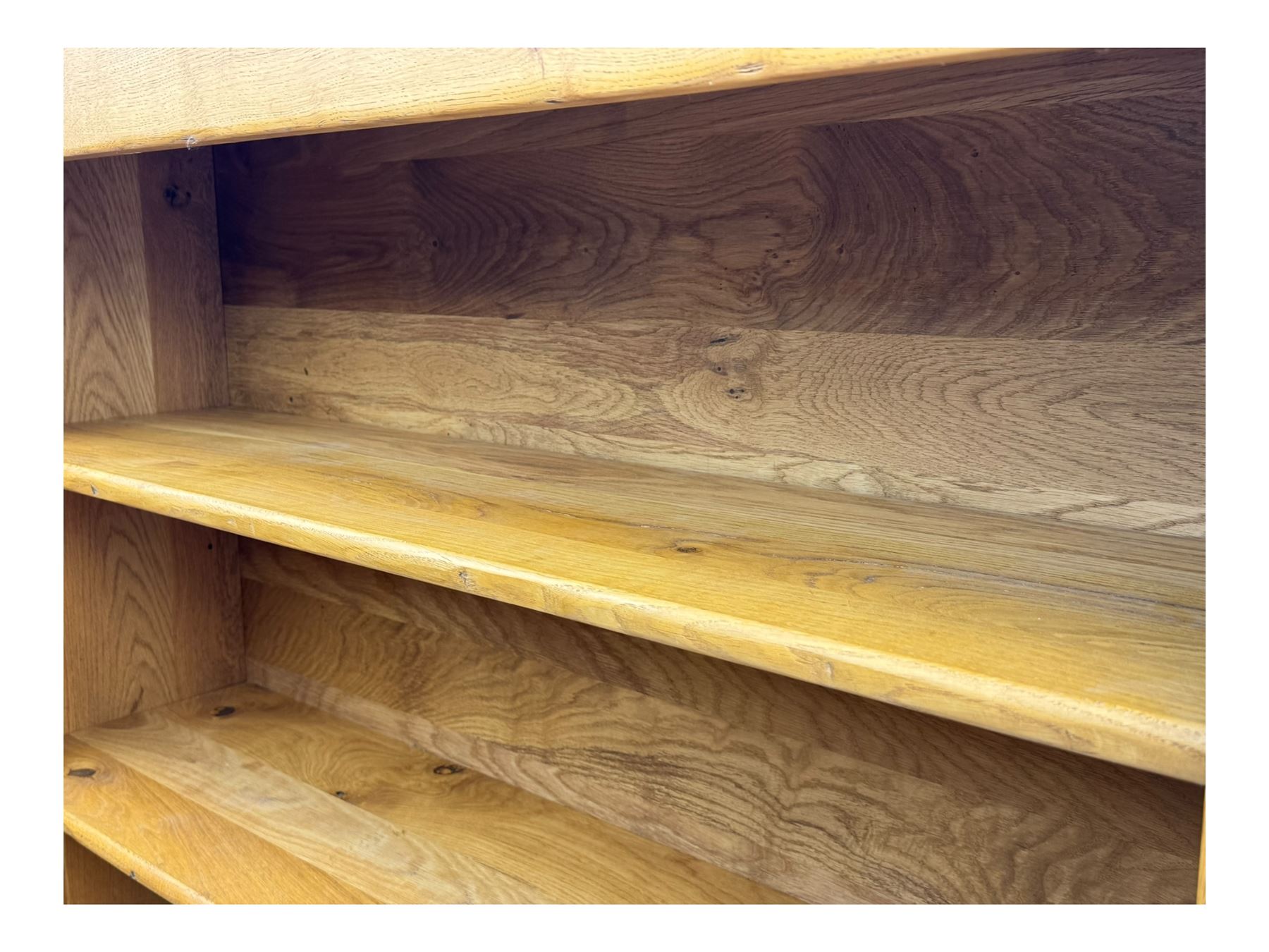 Contemporary French provincial design oak open bookcase, with projecting moulded cornice above a boarded back, fitted with four adjustable shelves, on bracketed plinth base