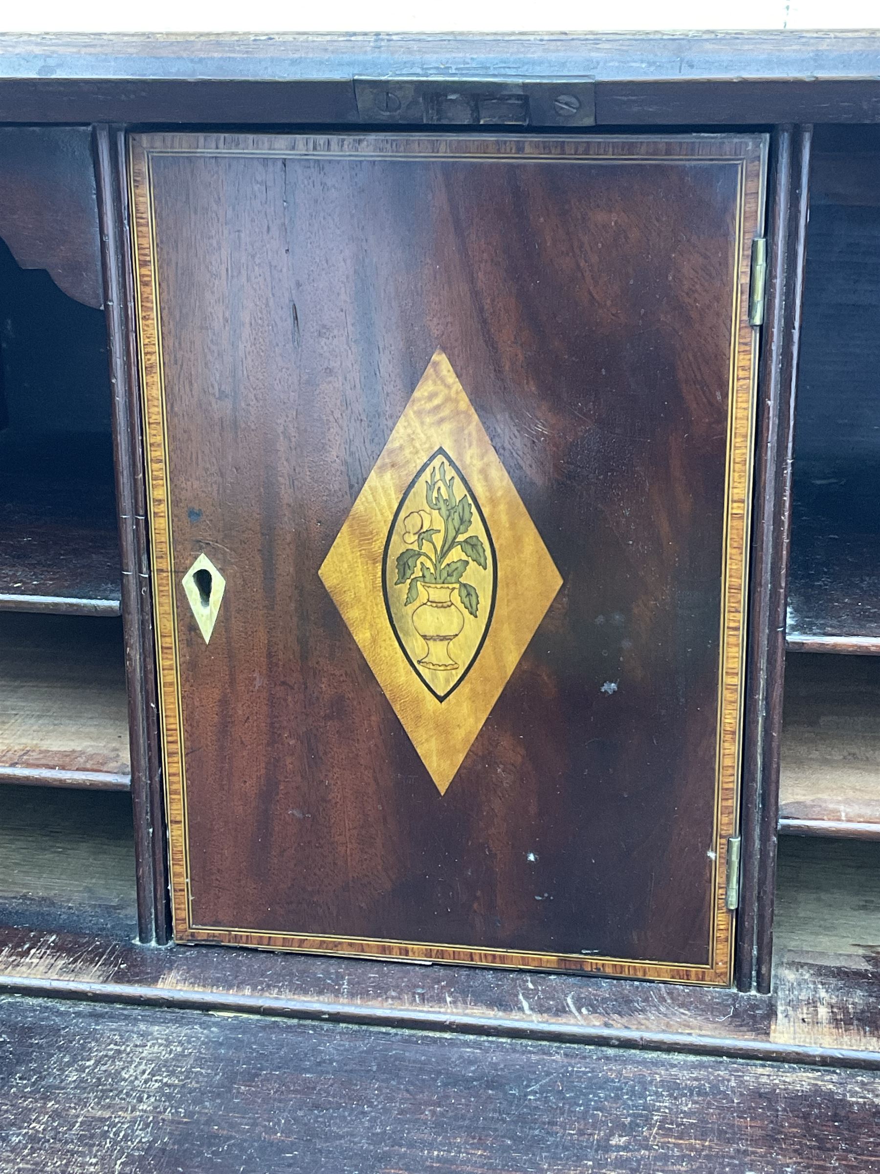 George III mahogany bureau, the conch inlaid fall front enclosing pigeon holes, shelves and central cupboard with inlaid flower motif, four graduating cock-beaded drawers below each with brass handles, lower moulded edge over shaped bracket feet