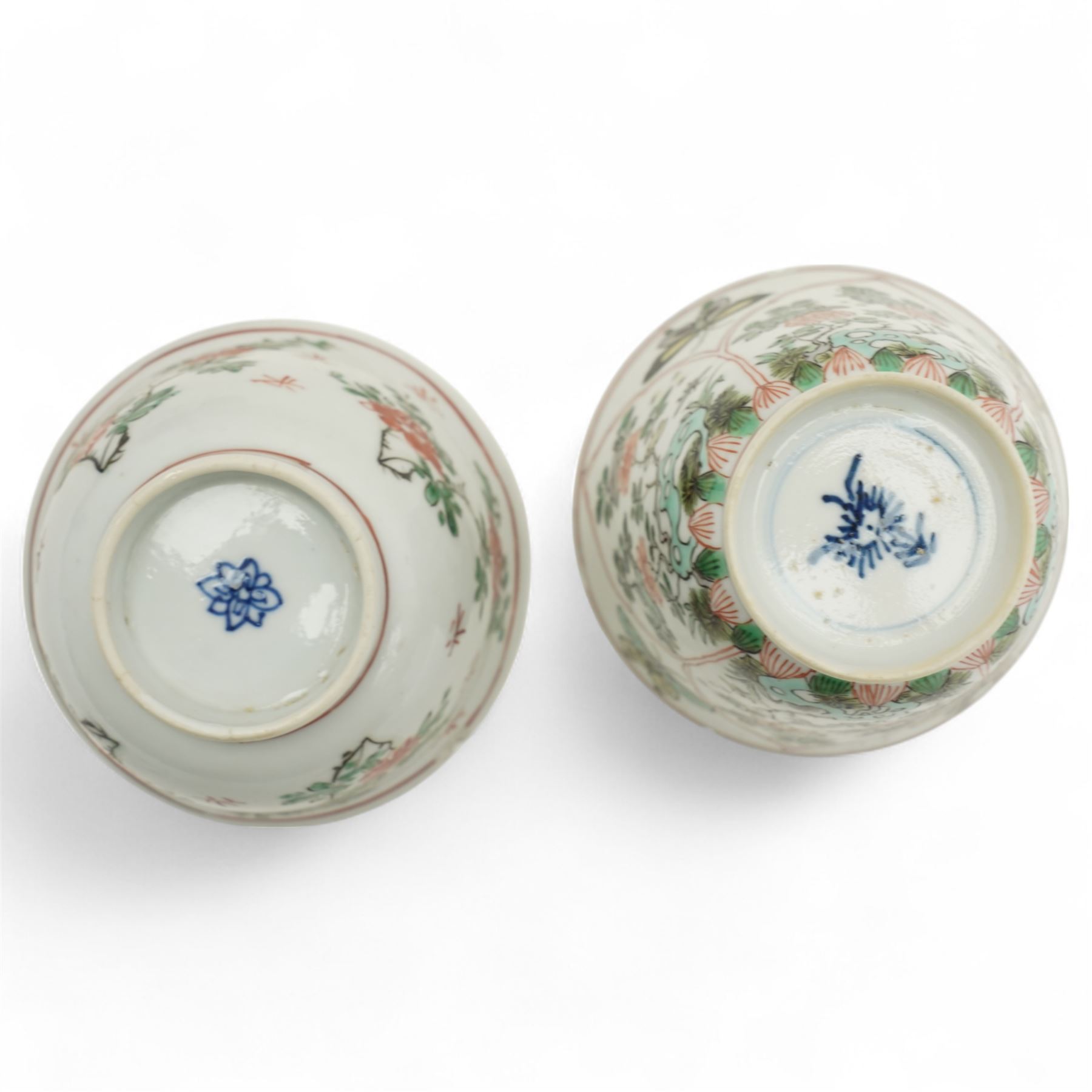 Three Chinese famille verte examples, approximately Yongzheng period, to include two teabowls and two saucers, each decorated with flowers and butterflies, two with sacred fungus mark within double rings, the teabowl with lotus mark, the other indistinct - possibly a Wan mark within lozenge (4)