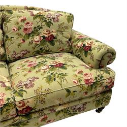 Hancock & Moore - two-seat sofa, upholstered in pale green ground fabric decorated with floral pattern, traditional shape with rolled arms and arched back, on turned front feet with brass cups and castors 