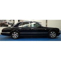 2001 Bentley Arnage Red Label Saloon

Registration: BU51 TGX
Engine: 6.75-litre turbocharged V8 petrol
Transmission: Automatic
Odometer reading: 39,942 miles
Colour: Black Sapphire metallic
Interior: Magnolia leather with burr walnut veneers
Previous owners: 3
V5C: Present
Service history: Good service records

An exceptional Bentley Arnage Red Label Saloon, finished in Black Sapphire metallic, a very dark blue, with a Magnolia leather interior, contrasting dark blue carpets and extensive burr walnut veneers. The car displays an odometer reading of approximately 39,942 miles.

The Arnage Red Label combined Bentley’s renowned 6.75-litre turbocharged V8 engine with automatic transmission, delivering effortless performance in a traditionally appointed luxury saloon. The model is distinguished by its imposing proportions, characteristic Bentley radiator grille and finely crafted interior.

Presented in excellent condition throughout, the bodywork and metallic paint finish appear particularly well preserved, complemented by clean brightwork and the correct Bentley alloy wheels. The engine bay is also notably well detailed.

The interior presents exceptionally well, retaining its Magnolia leather upholstery, polished burr walnut veneers, original factory instrumentation and switchgear. The leather displays only light creasing consistent with careful use.

The car has had three previous owners and is accompanied by good service records.

Features

• 6.75-litre turbocharged V8 petrol engine
• Automatic transmission
• Black Sapphire metallic paintwork
• Magnolia leather interior
• Contrasting dark blue carpets
• Burr walnut veneers
• Electrically adjustable front seats
• Air conditioning
• Factory instrumentation and switchgear
• Bentley alloy wheels
• Right-hand drive
• Odometer reading of approximately 39,942 miles
• Three previous owners
• Good service records
• V5C present

This vehicle forms part of the Estate of the Late John Sills and is offered for sale by the Executors, confirming a genuine reason for sale.