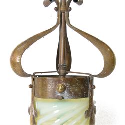 Arts & Crafts brass ceiling lantern with a trio of fluer-de-lis mounted arms, the vaseline glass pendant light shade of cylindrical form with flared rim, H52cm