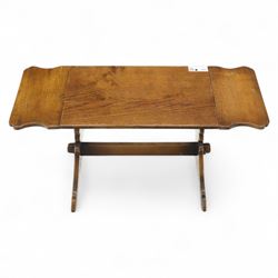 Early 20th century oak drop leaf cottage table, rectangular top with twin hinged leaves, on shaped trestle end supports united by central stretcher