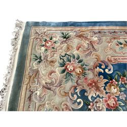Large Chinese blue ground woollen carpet, overall floral design, central oval medallion surrounded by scrolling floral decoration, wide border with decorated with floral bouquets 
