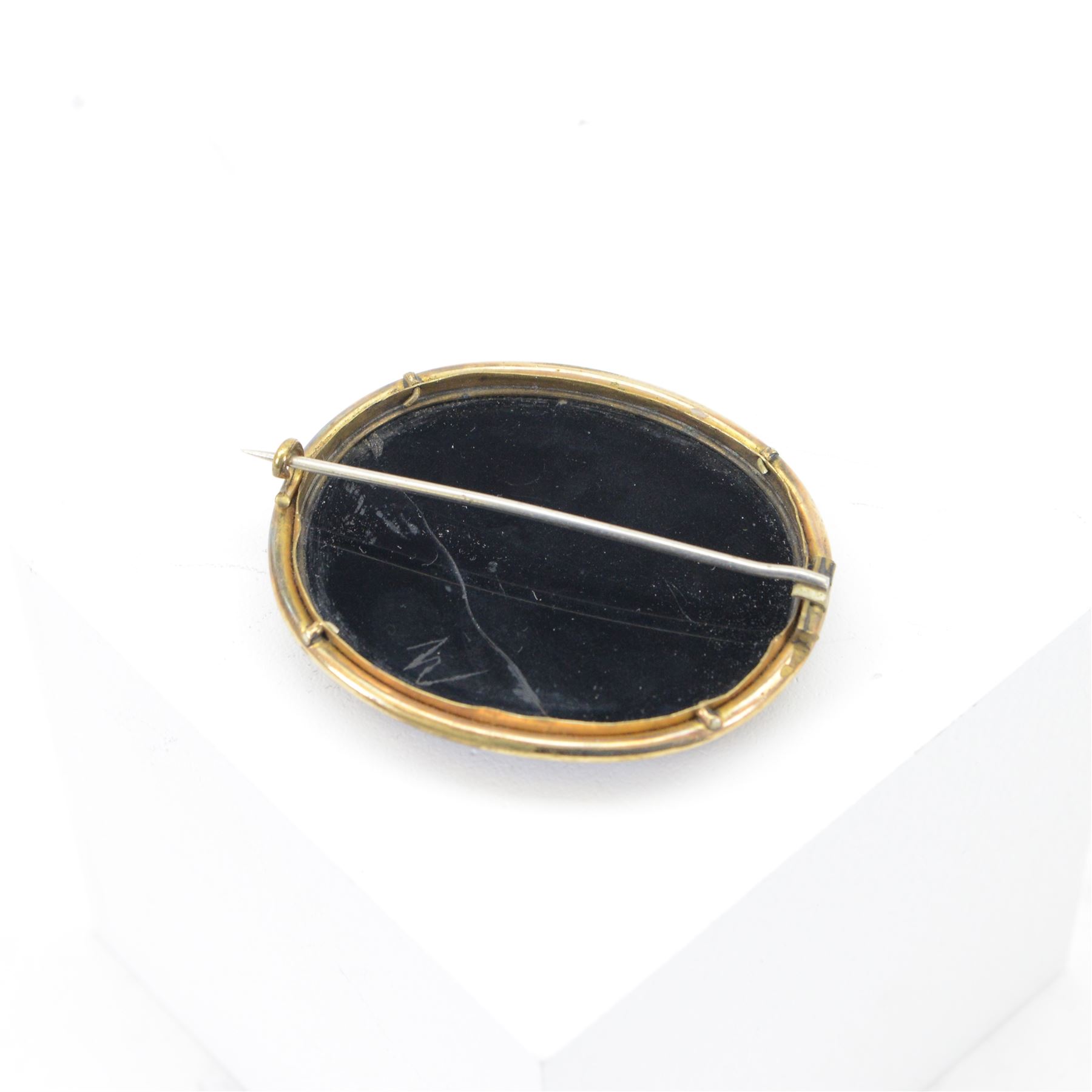 Micro mosaic brooch of Pliny Doves, the oval black panel set with a micro mosaic of doves drinking from a water bath, within a gilt metal setting 