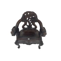 Japanese Meiji period open armchair, the back carved and pierced with dragon and scrolling scaled tails, projecting dragon carved arm terminals on scrolled supports, serpentine seat with decorative band, the apron and supports with scroll and chip-carved decoration
