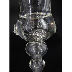 19th century drinking glass, the trumpet bowl with oblique trailing upon a multi annulated knopped stem and folded circular foot, H18.5cm, together with a further 19th century drinking glass, the bell shaped bowl with prunt detail, upon stem with conjoined baluster and folded circular foot with conforming prunt detail, H16cm