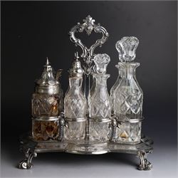 Victorian silver cruet stand, containing eight cut glass cruet bottles, four with silver covers, upon a shaped base with four scroll feet and loop handle, chased with floral and foliate decoration, the stand, base and bottle caps all hallmarked John, Edward, Walter & John Barnard, London 1872, one bottle with a matched silver cruet spoon, stand H30cm