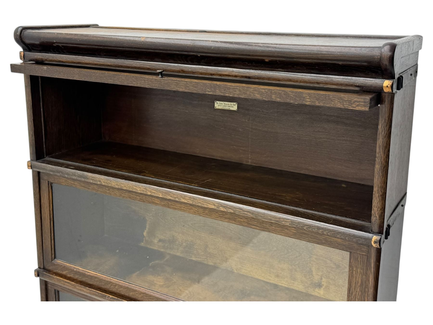 Globe Wernicke - stacking sectional library bookcase, over four glazed up-and-over doors, each bearing original makers mark, on moulded plinth base with inbuilt drawer