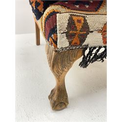 Late 20th century beech framed wingback armchair, sprung seat and back upholstered in kilim cover, acanthus carved cabriole supports with ball and claw feet