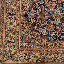 Persian Kashan rug, navy field with lobed central medallion and scrolling floral sprays, ivory spandrels within a palmette and vine border