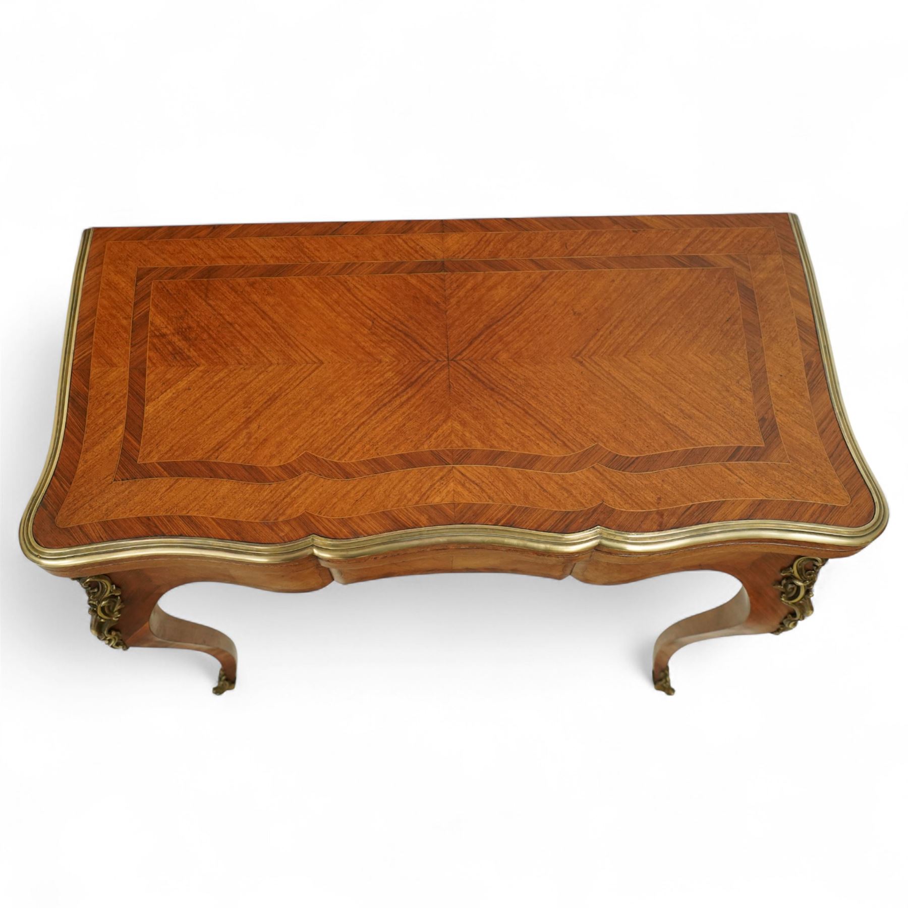 Early 20th-century Louis XV-style kingwood and tulipwood marquetry card table, shaped rectangular hinged top revealing baize-lined interior, with quarter-veneered parquetry within crossbanded borders and mounted with a gilt bronze edge, above a serpentine frieze,  raised on cabriole legs with gilt bronze foliate mounts and sabots 