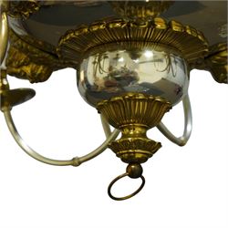 Regency Revival chromium-plated and gilt-brass nine-light chandelier of Neoclassical design, the dished central bowl applied with substantial gilt winged cherub-mask mounts and issuing nine scrolling branches with circular drip pans and faux candle sleeves, over a spherical terminal with gilt-metal gadrooned flower-petal collar and ring, max. diameter 75cm