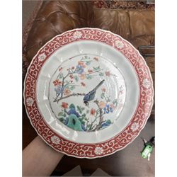 Chinese Kangxi famille verte plate, decorated with a bird perched upon a blossoming branch, within an iron red foliate border, D22cm