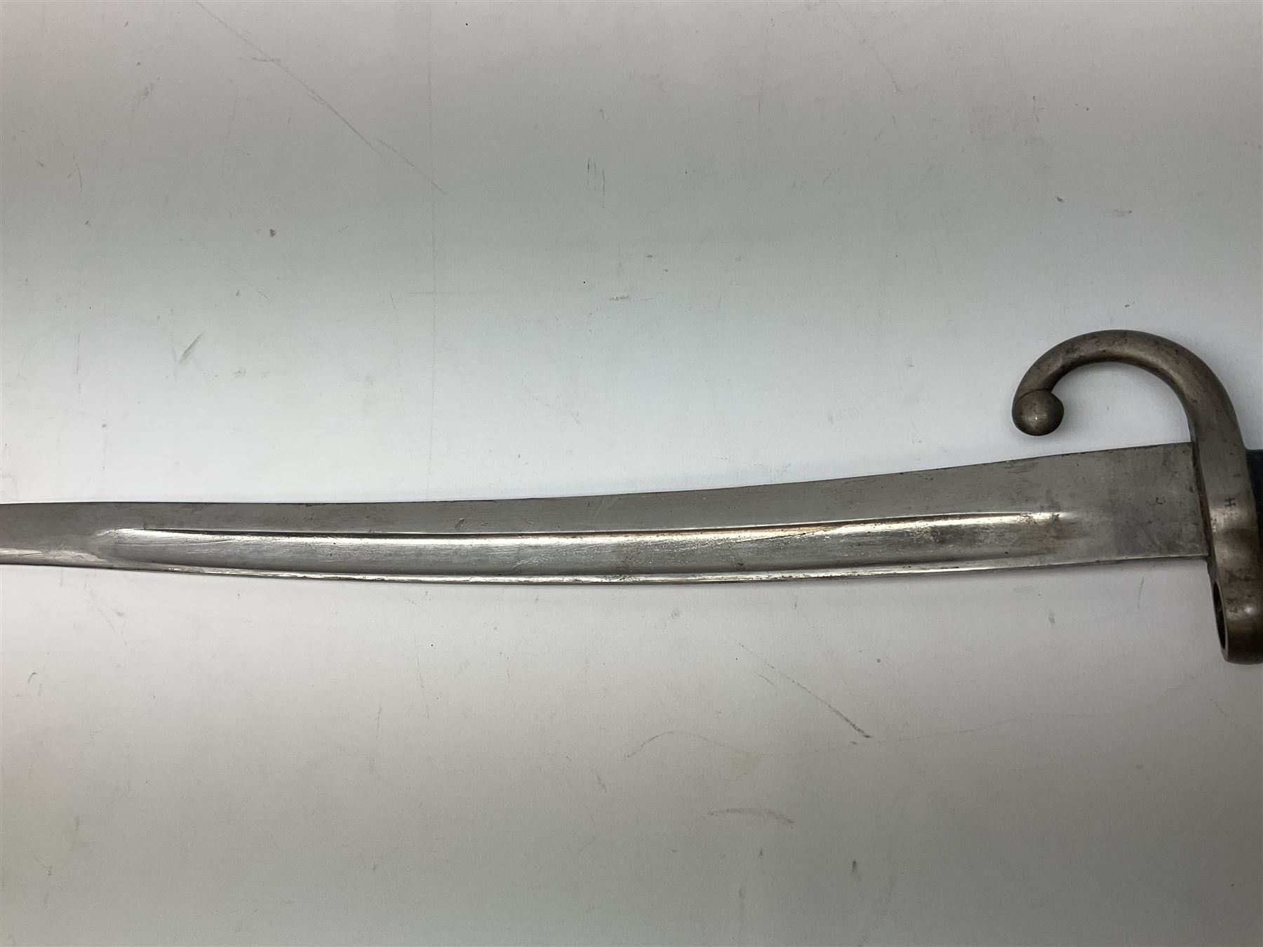 Turkish Model 1874 sword bayonet with 57.5cm curving steel fullered blade and chequered black grip, in steel mounted leather scabbard L75.5cm overall