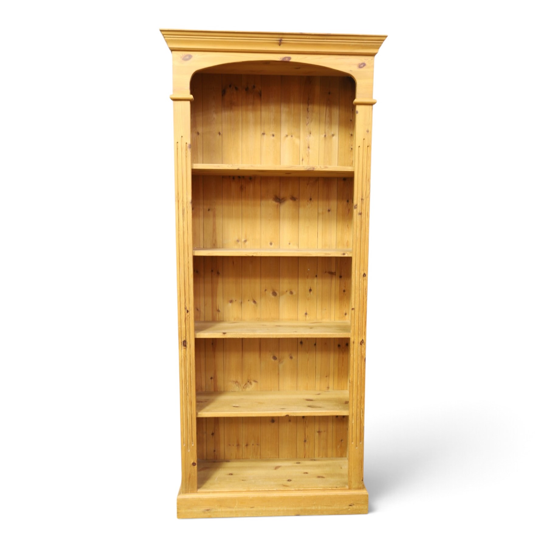 Traditional pine bookcase, projecting cornice with four fixed shelves (H 33cm, D 29cm), fluted sides, raised on a plinth base