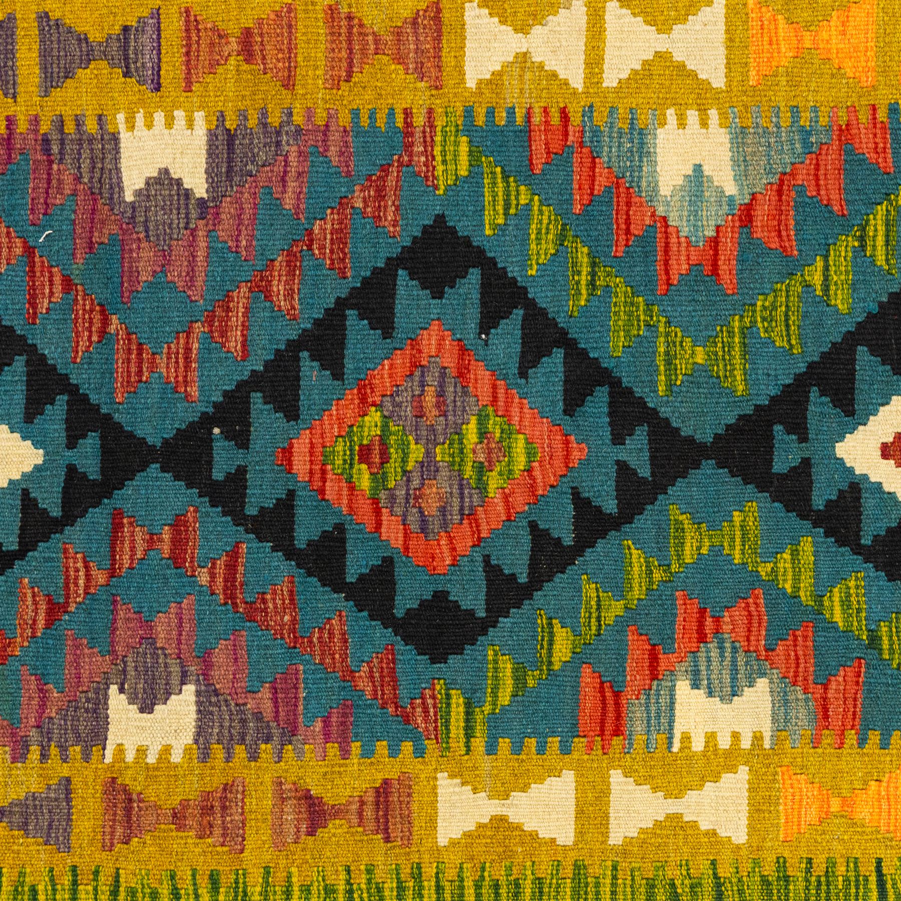 Maimana kilim flatweave runner, central field features a large bold nested diamond motif and stylized geometric lozenge patterns on olive purple, blue, and green tone ground, border stripe in teal ground, and fringe