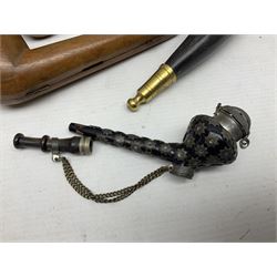 Swiss mountain hunters tobacco pipe with a horn mouthpiece, metal hinged pierced lid and brass chain, the black coated body adorned with small metal cow flowers, together with two other pipes and case, brass mounted horn, brass mounted bone box, carved mother of pearl handled knife and fork and brass jug