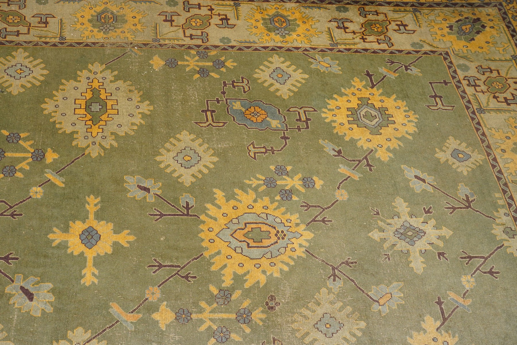 Lage Turkish Oushak green ground carpet, the field decorated with large stylised plant motifs and geometric design, the sage green guard band with further repeating foliate motifs