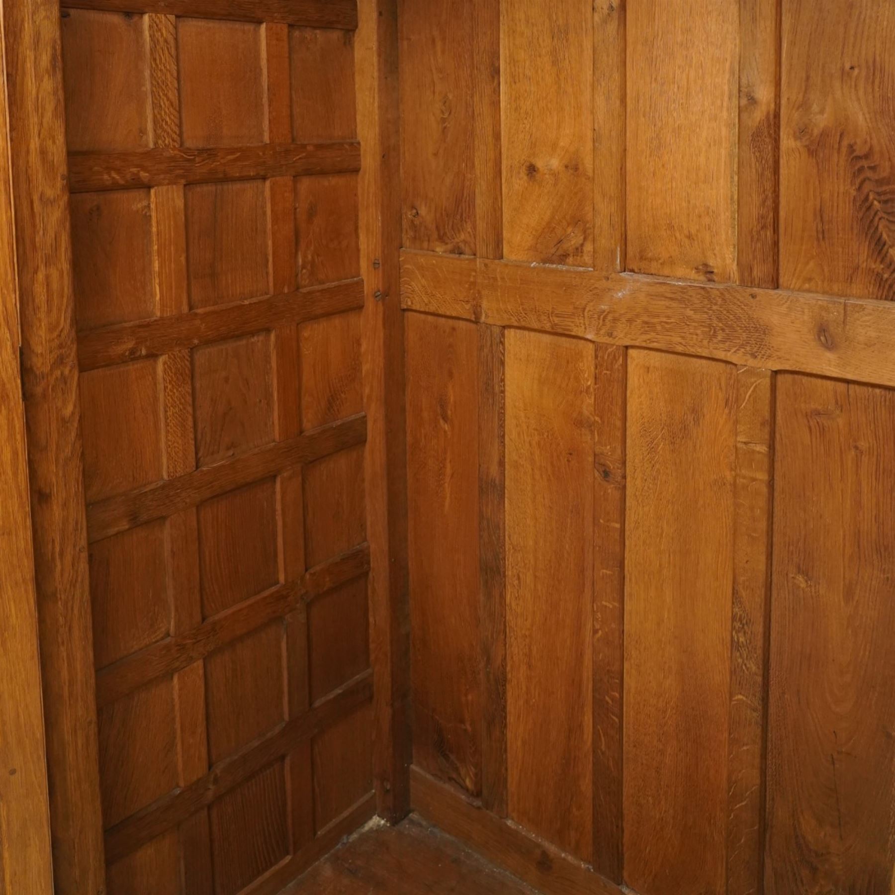 Mouseman - early-to-mid-20th century figured panelled and adzed double wardrobe of large proportions, the arcade carved cresting rail over two doors with adzed and figured oak panels, with wrought metal hinges and latch, relief carved mouse signature, the interior fitted with hanging rail, by the workshop of Robert Thompson, Kilburn