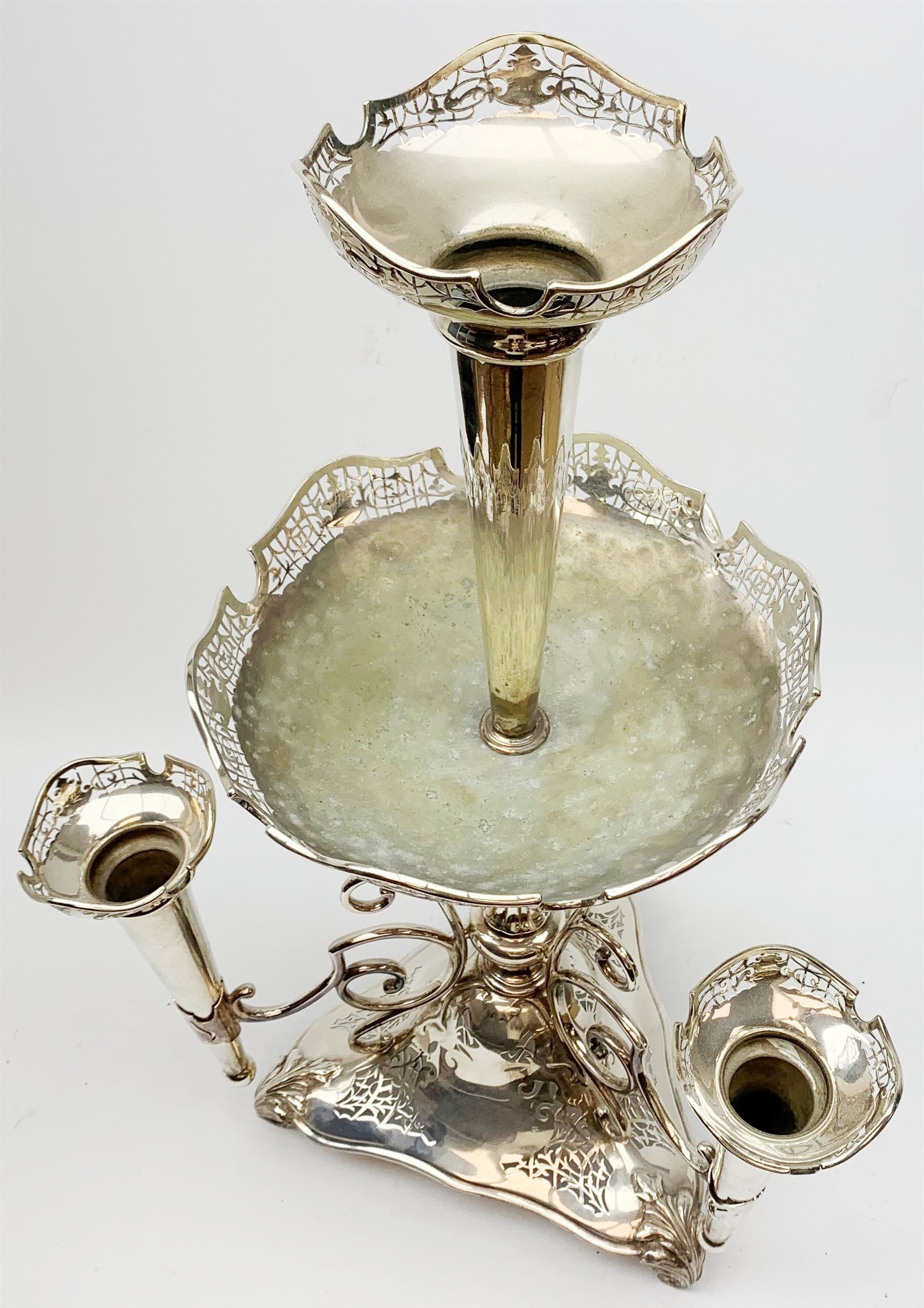 Large James Deakin and Sons silver plated epergne, c.1900, the central trumpet with pierced rim, above a large shallow bowl, upon a reeded column supporting three scrolling branches with conforming smaller trumpets, raised upon a triangular pierced base with three scroll feet, with marks beneath, JD & S, EPNS , and 'desk bell', T9518, H69cm