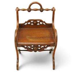 Late 19th century Gothic Revival carved oak hall chair or window seat, the swell-turned top rail centred by an arched carrying handle, over shaped open arms and solid plank seat, with pierced and carved scrolling foliate fretwork side panels and apron with applied central roundel, raised on shaped supports united by turned stretcher