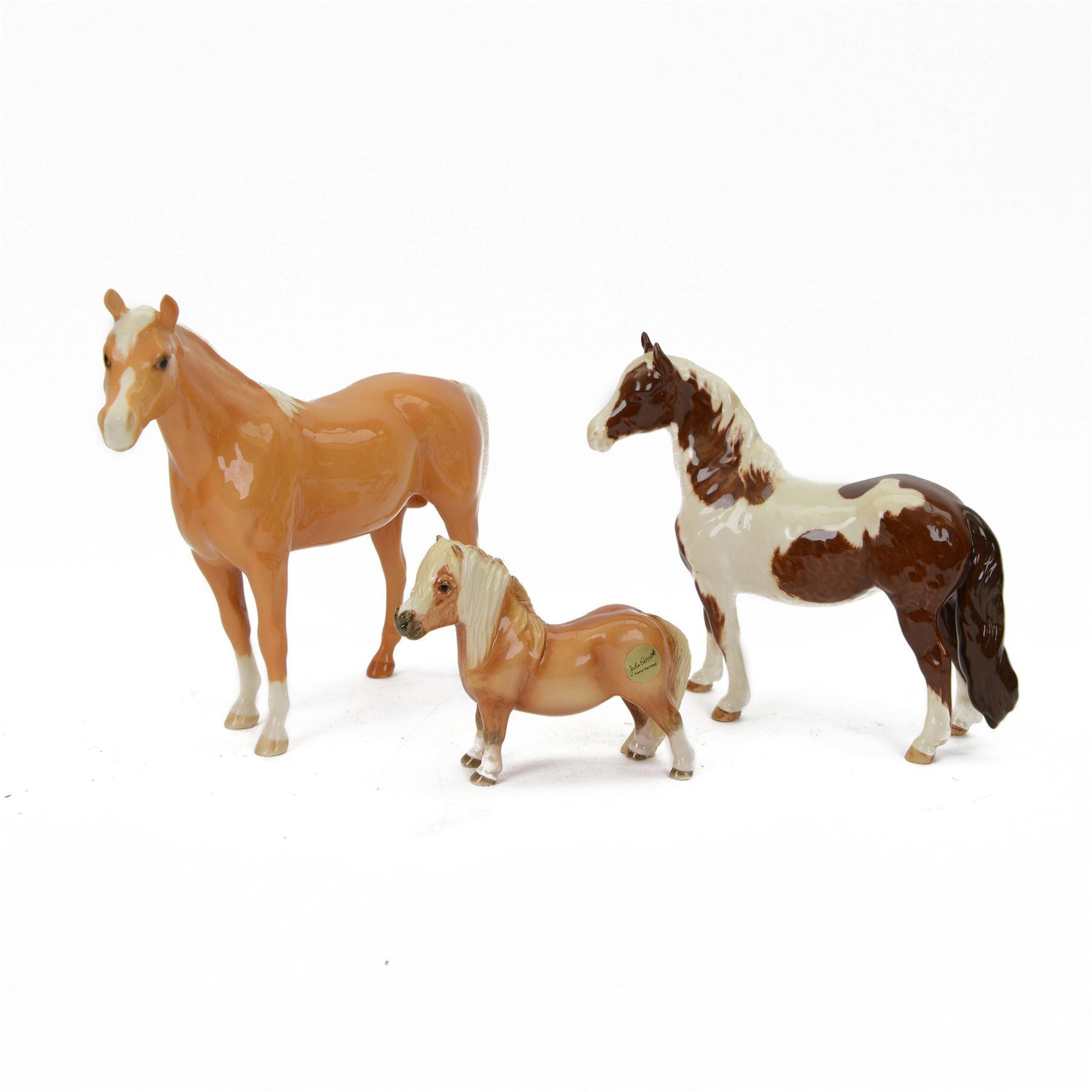 Three Beswick Horses, comprising skewbald Pinto Pony no 1373, Palomino horse and Palomino shetland