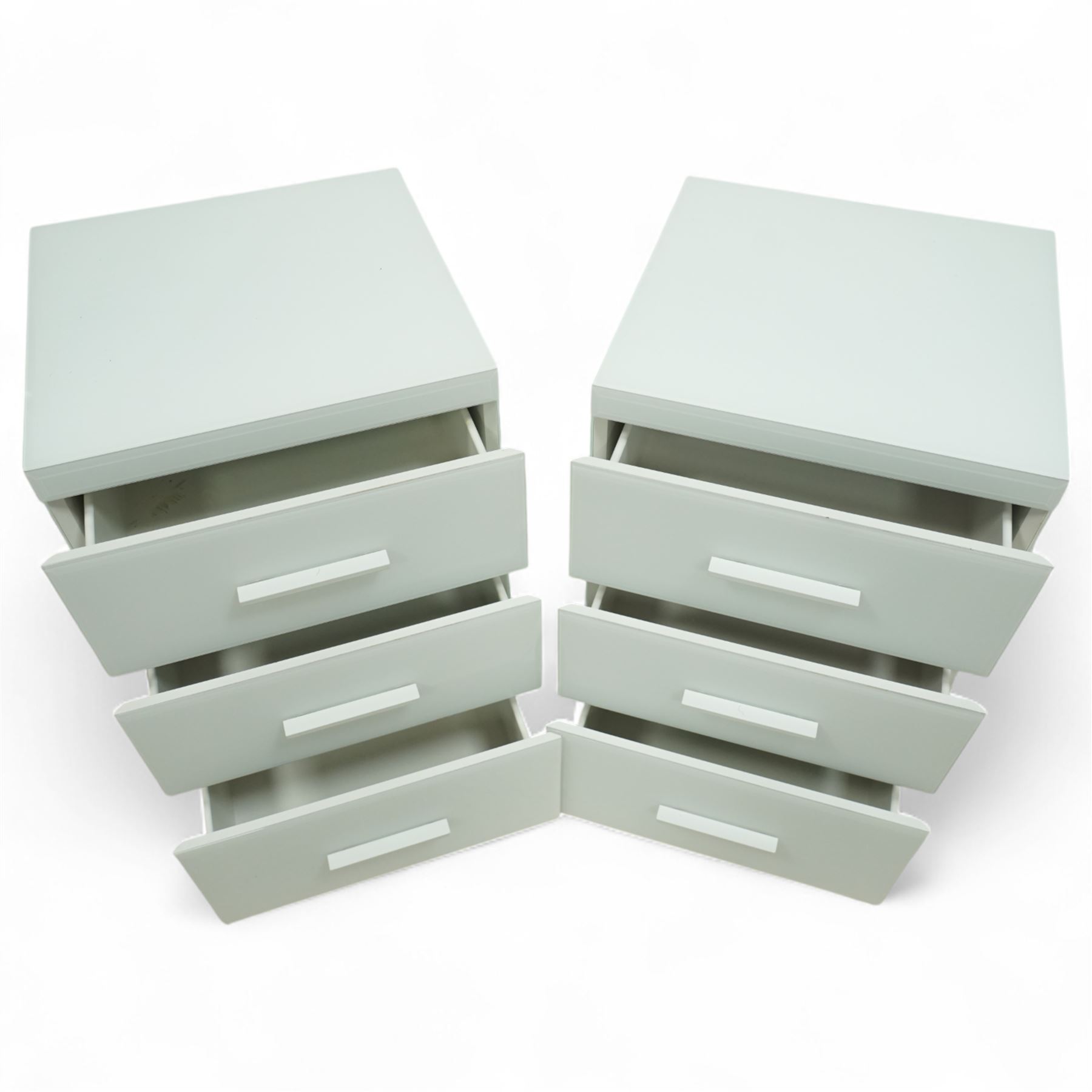Pair of contemporary white and glass bedside chests, with square top over three drawers with integrated handles, plain sides and plinth bases