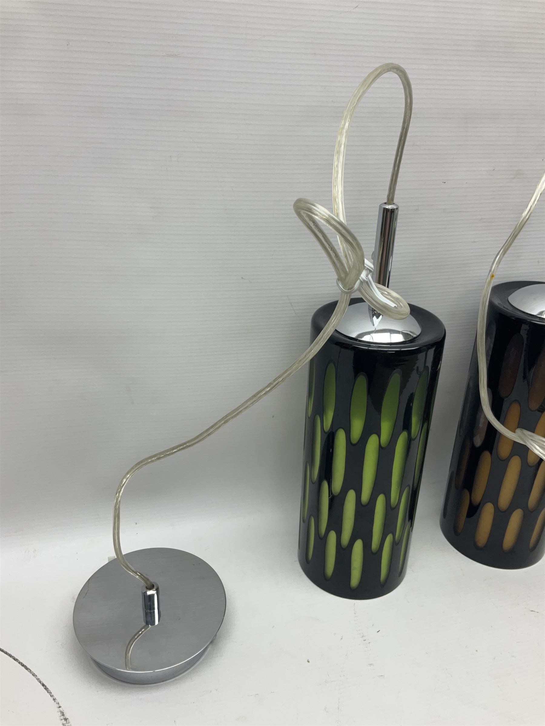 Three contemporary glass pendant lights, the black glass glass cut away revealing green and brown beneath, H24cm