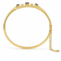 Early 20th century 18ct gold sapphire and diamond hinged bangle, the front set with three round cut sapphires and spaced by two old cut diamonds, total sapphire weight approx 1.15 carat