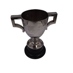 1920s silver trophy cup, with angular twin handles, upon knopped stem with circular spreading foot, the body with presentation engraving 'Burniston & District Show, presented by S Fox Linton TD MD, for the Best Agricultural Mare or Gelding, 10 miles radius, 1928' and engraved with winners verso, hallmarked Charles Boyton & Son 1921, upon black plastic base, including base 25cm