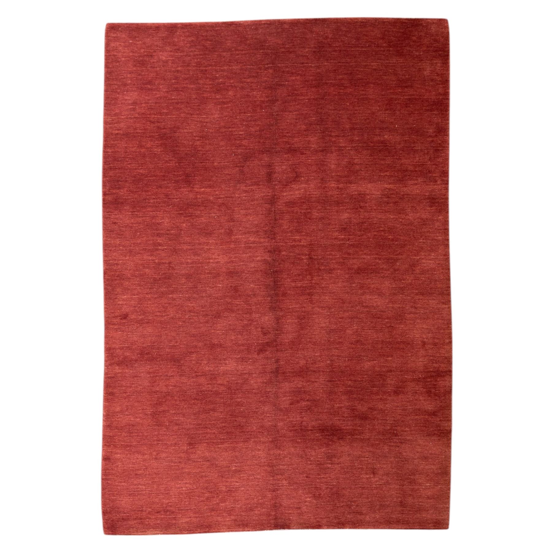 Modern Gabbeh red wool rug, plain madder red field with subtle tonal variation and abrash