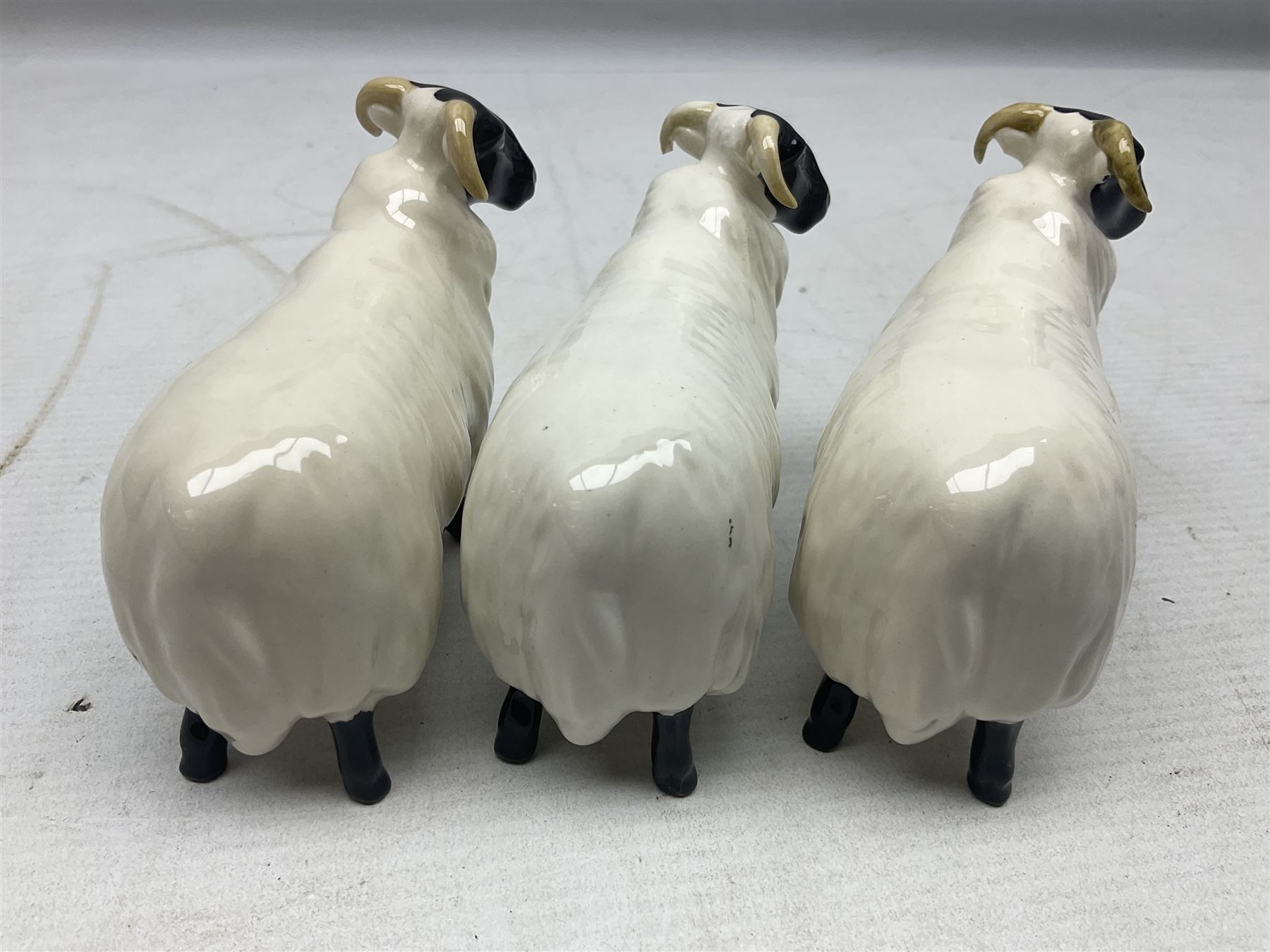 Seven Beswick figures of sheep comprising three ewes and four lambs, together with a figure of a sheepdog (8)