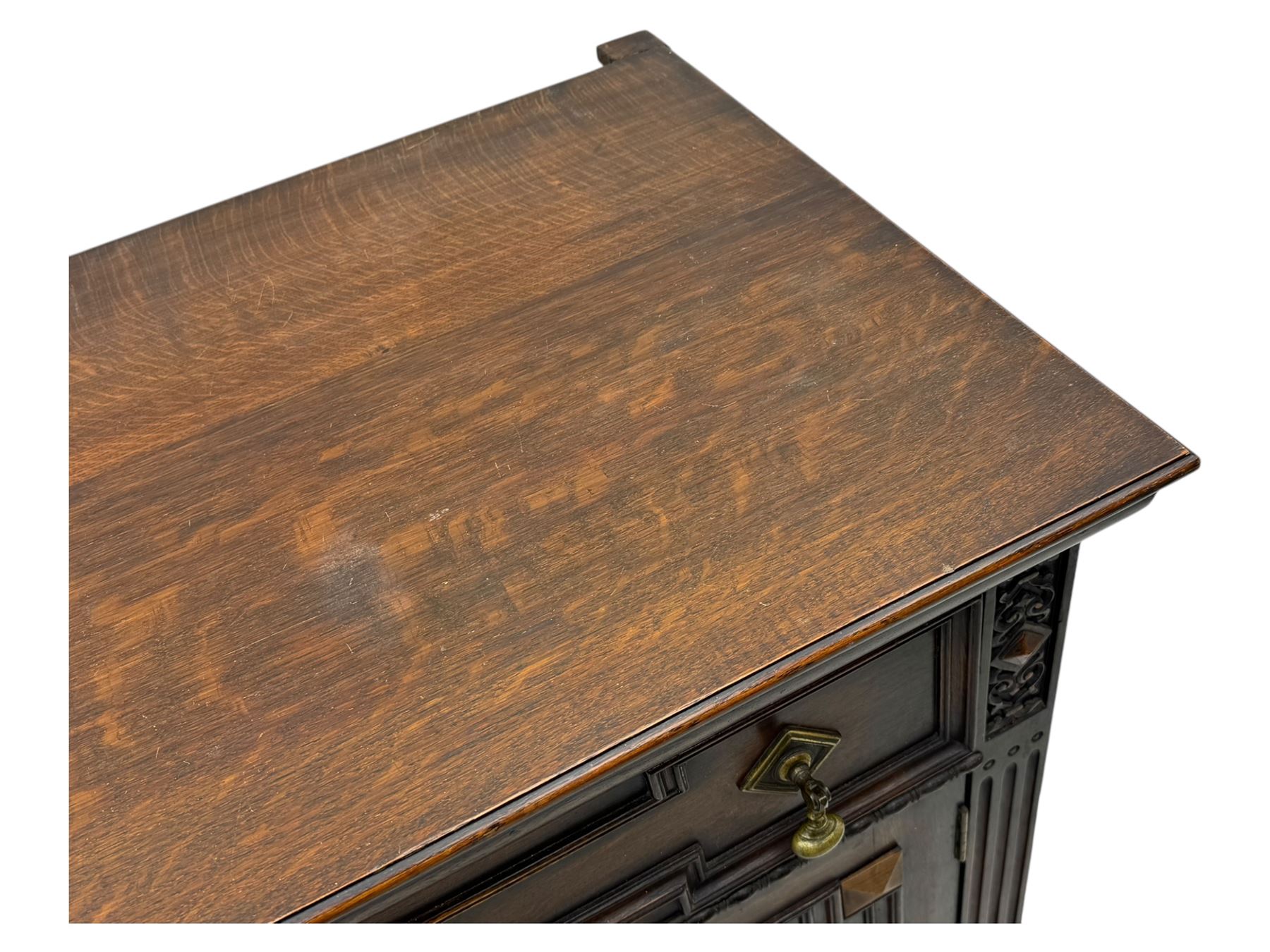 Jacobean-style oak dresser base with two frieze drawers above three cupboards with panelled and moulded decoration, fitted with drop handles, supported on bun feet, circa 1900