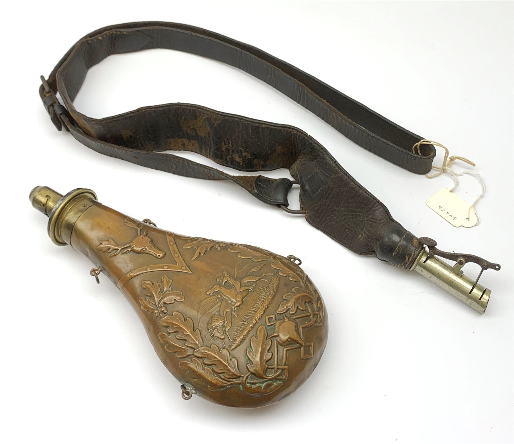 Victorian large copper powder flask embossed with a hunting scene within an oak leaf border with stag and fox heads, the nozzle marked 'Extra Quality Sykes Patent', fitted with four suspension rings H24cm; together with Victorian leather shoulder shot flask with Sykes nozzle L80cm (2)