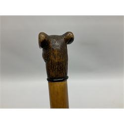 20th century walking cane, the carved wooden handle modelled as the head of a dog with inset glass eyes and articulated and sprung jaw, upon a tapering Malacca shaft, L93cm