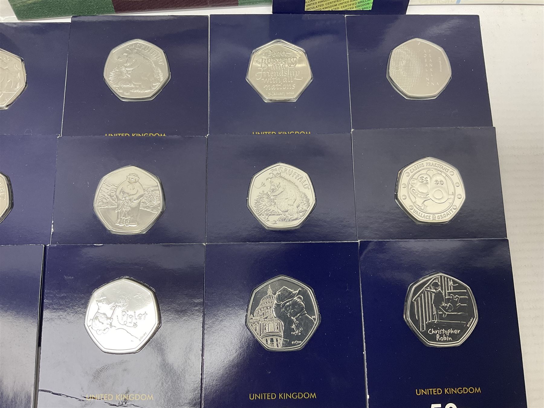 Mostly United Kingdom Queen Elizabeth II commemorative fifty pence coins, including 2019 'Gruffalo', 2020 'Iguanodon', 2022 'The Queen's Jubilee' etc, housed on cards, face value of UK coins approximately 20 GBP