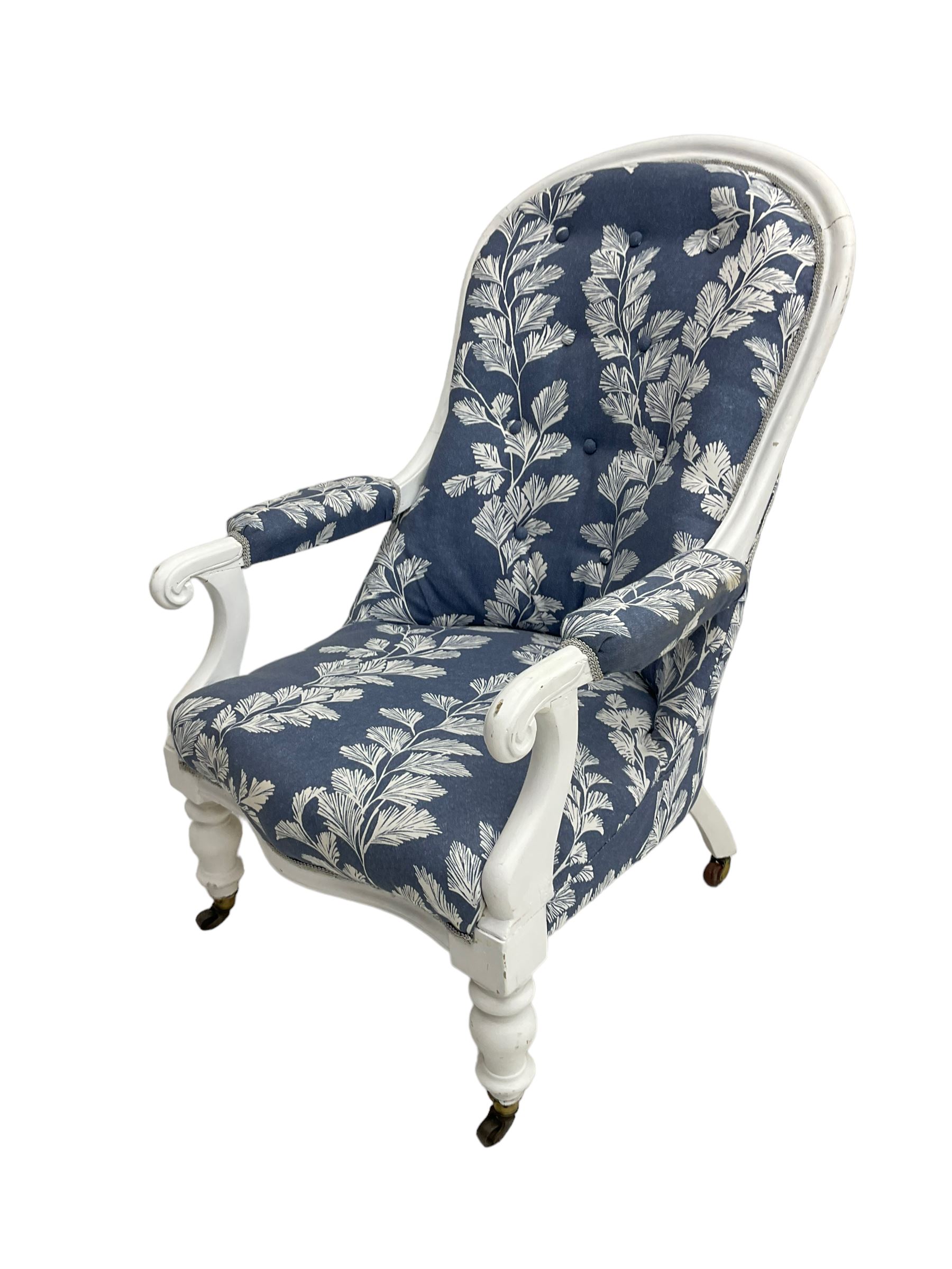 Victorian white painted open armchair, upholstered in blue fabric decorated with trailing leaf pattern, scrolled arm terminals on turned front supports with castors