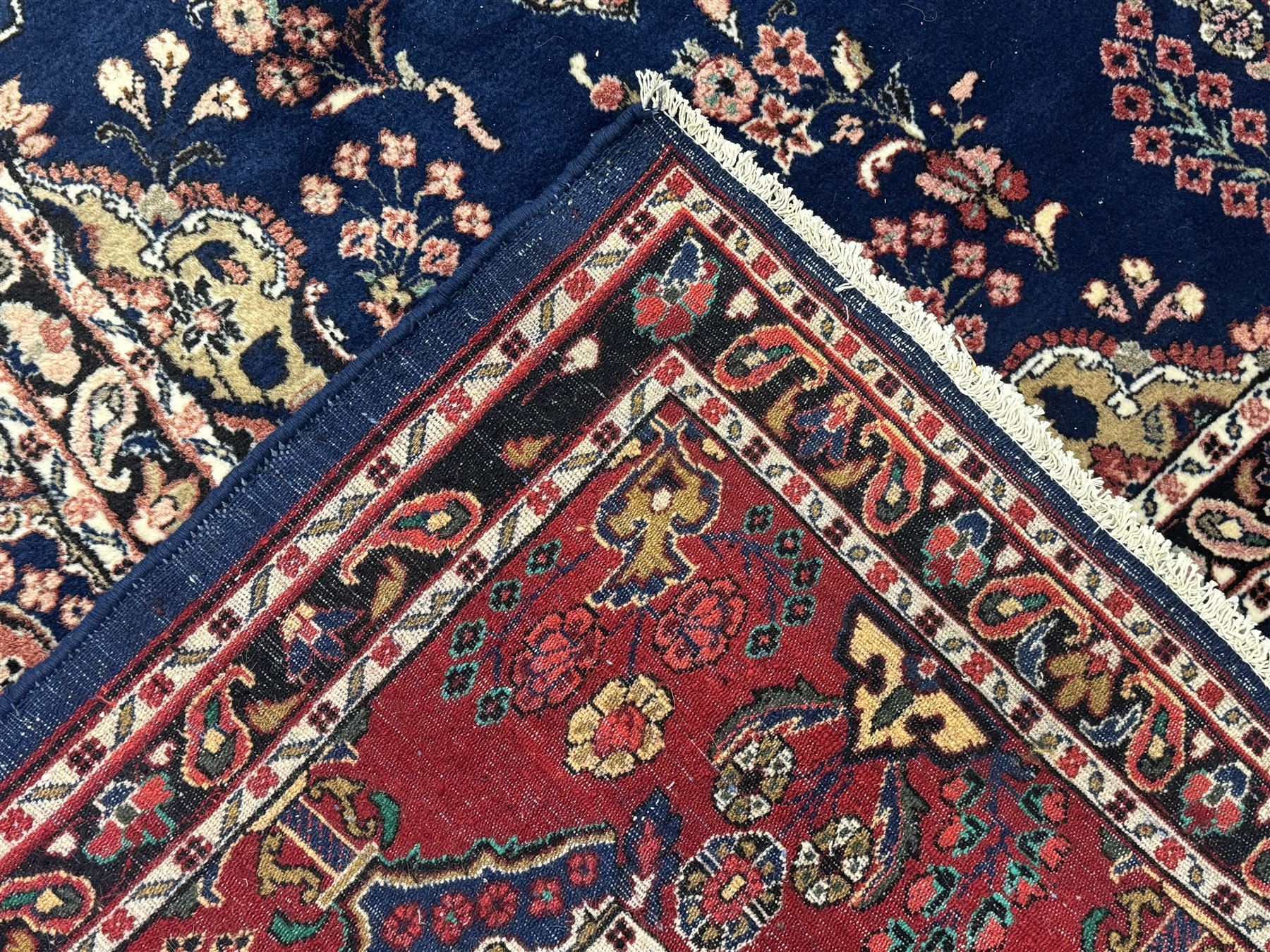 Persian Herati design indigo and red ground carpet, decorated with floral motifs, arched border