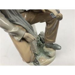 Lladro figure, Violinist, modelled as a man seated upon a  mile stone holding a violin, sculpted by Salvador Furió, no 4887,  year issued 1984, year retired 1981, H35cm