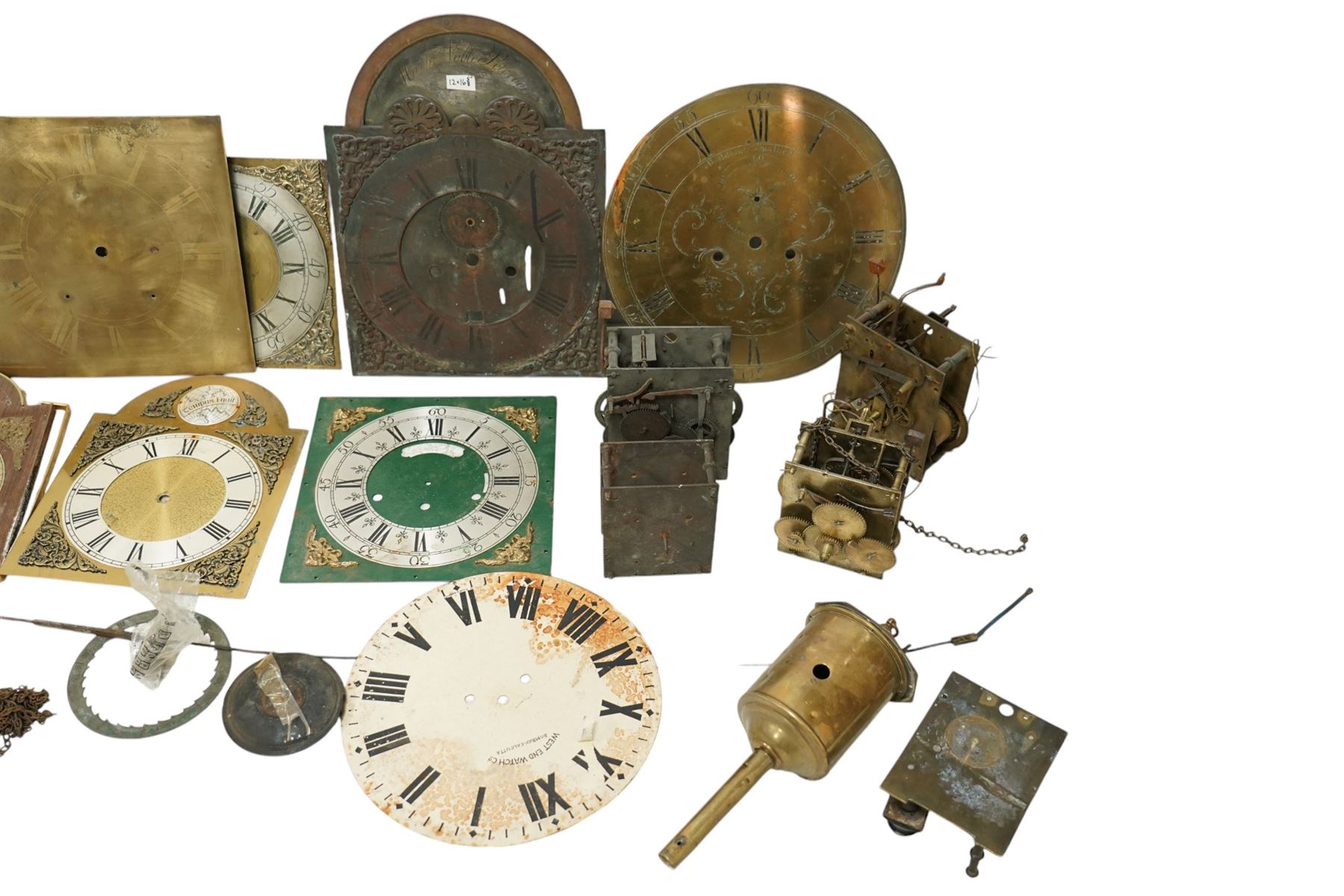 An 8-day longcase clock movement with a painted dial and various 8-day and 30-hour long case movements, dials, parts, plates, chains, and two lead weights, sold as incomplete for parts and restoration projects. 