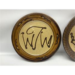 Michael Leach (British 1913-1985) for Yelland pottery; two large glazed stoneware plates with dark brown stylised decoration upon oatmeal ground, together with a jug in merging blue, green and brown, all with impressed marks beneath, largest plate D37cm